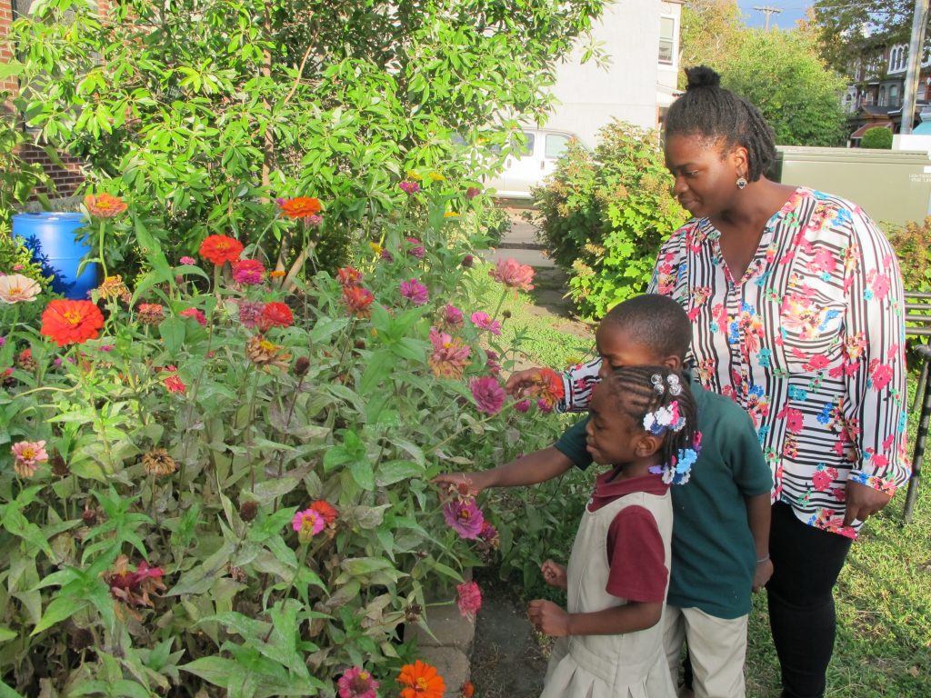 Teyanna Pridgen admires the wildflower garden at Mercy Neighborhood Ministries with her son and daughter. Both of the children attend the center’s preschool.