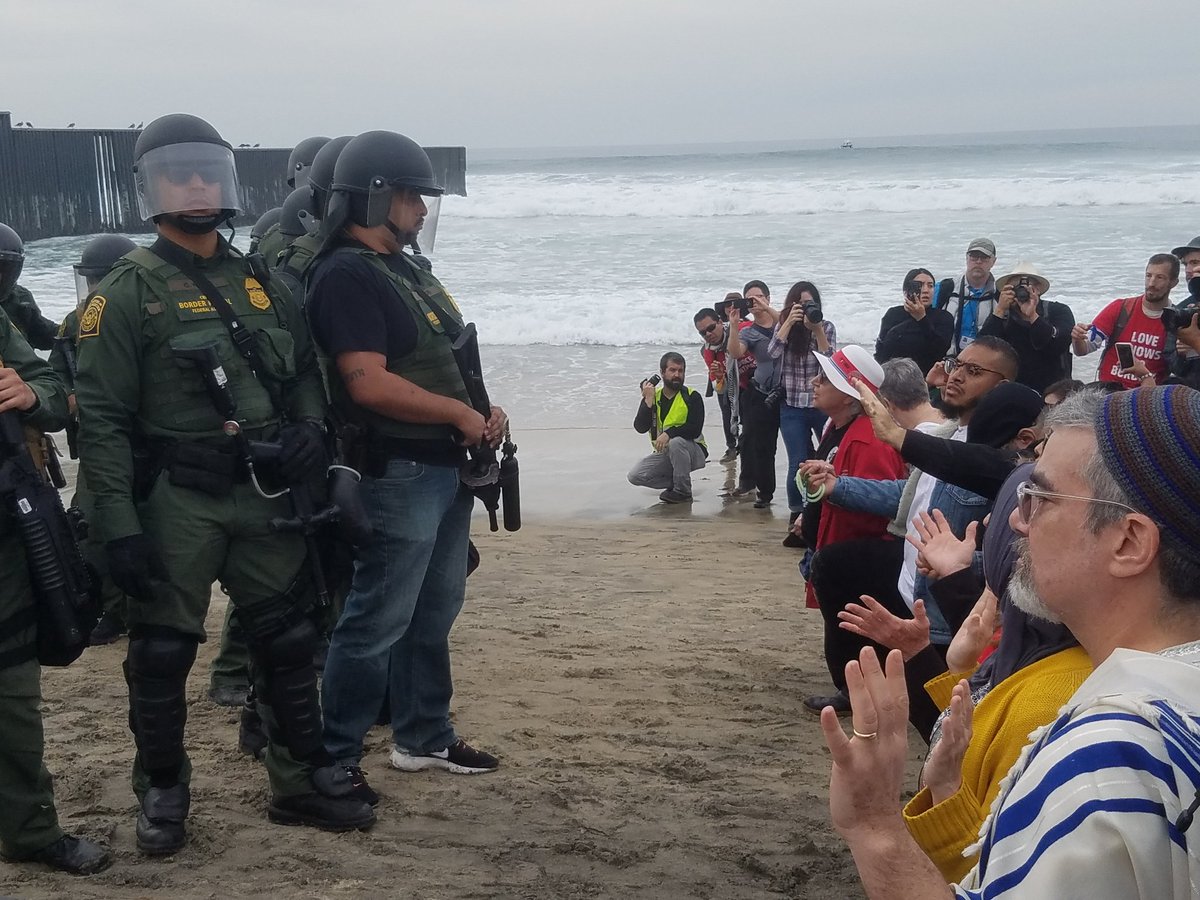 People risking arrest kneeing in from of Customs and Border Patrol agents