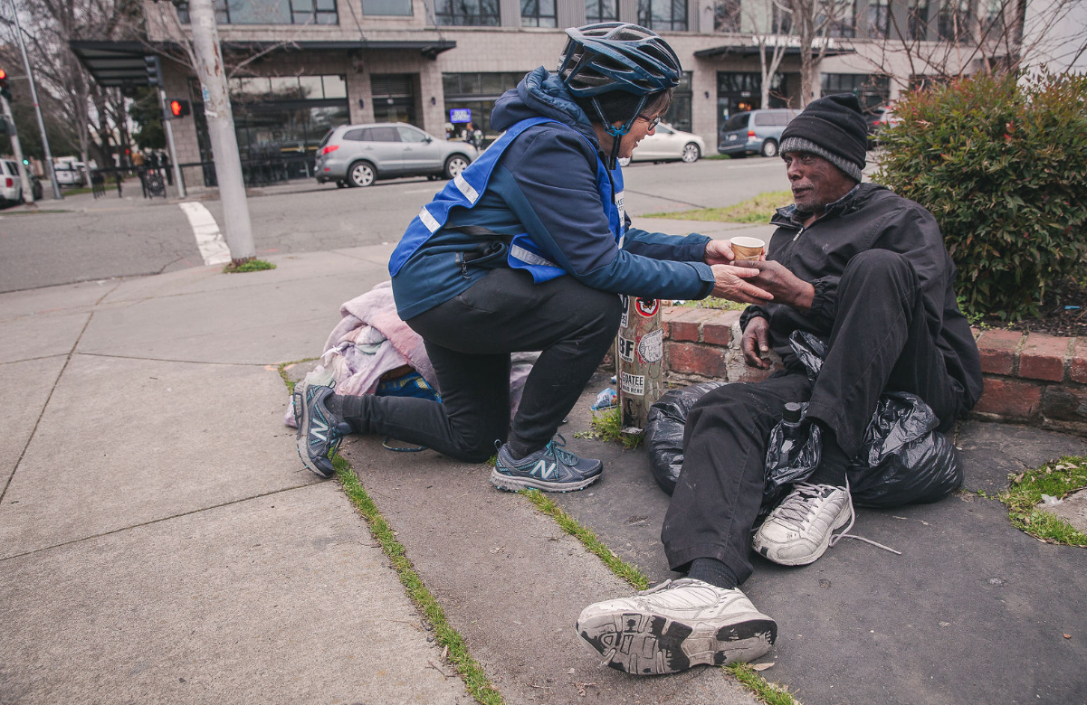 Sister Libby serving a cup of coffee to one of the people she meets on her Mercy Pedalers route. Photo via Create + Gather