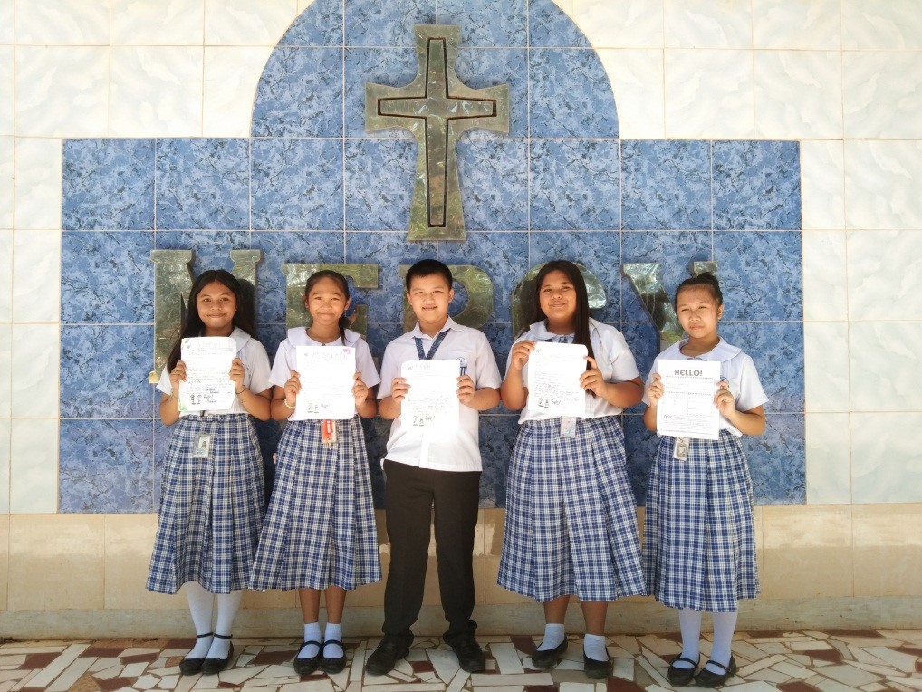 Estudiantes de Mercy Junior College muestran las cartas que recibieron de sus amigas y amigos por correspondencia en los Estados Unidos.