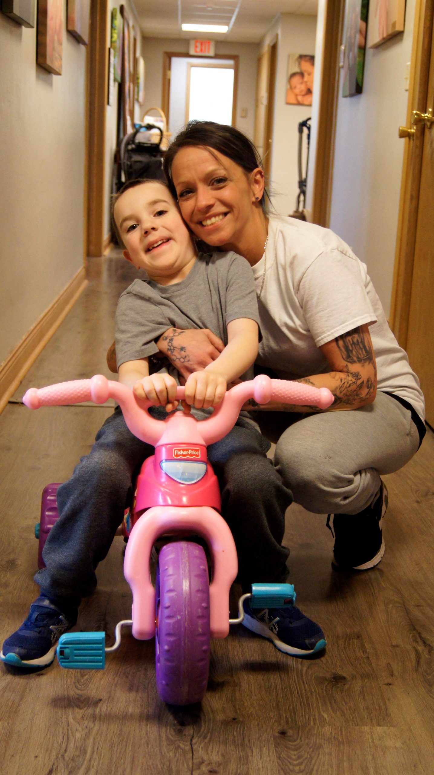 Krystle, one of the mothers and former resident of Bethlehem House, with her son on his favorite big wheel. She has earned her GED and will begin college courses this year.