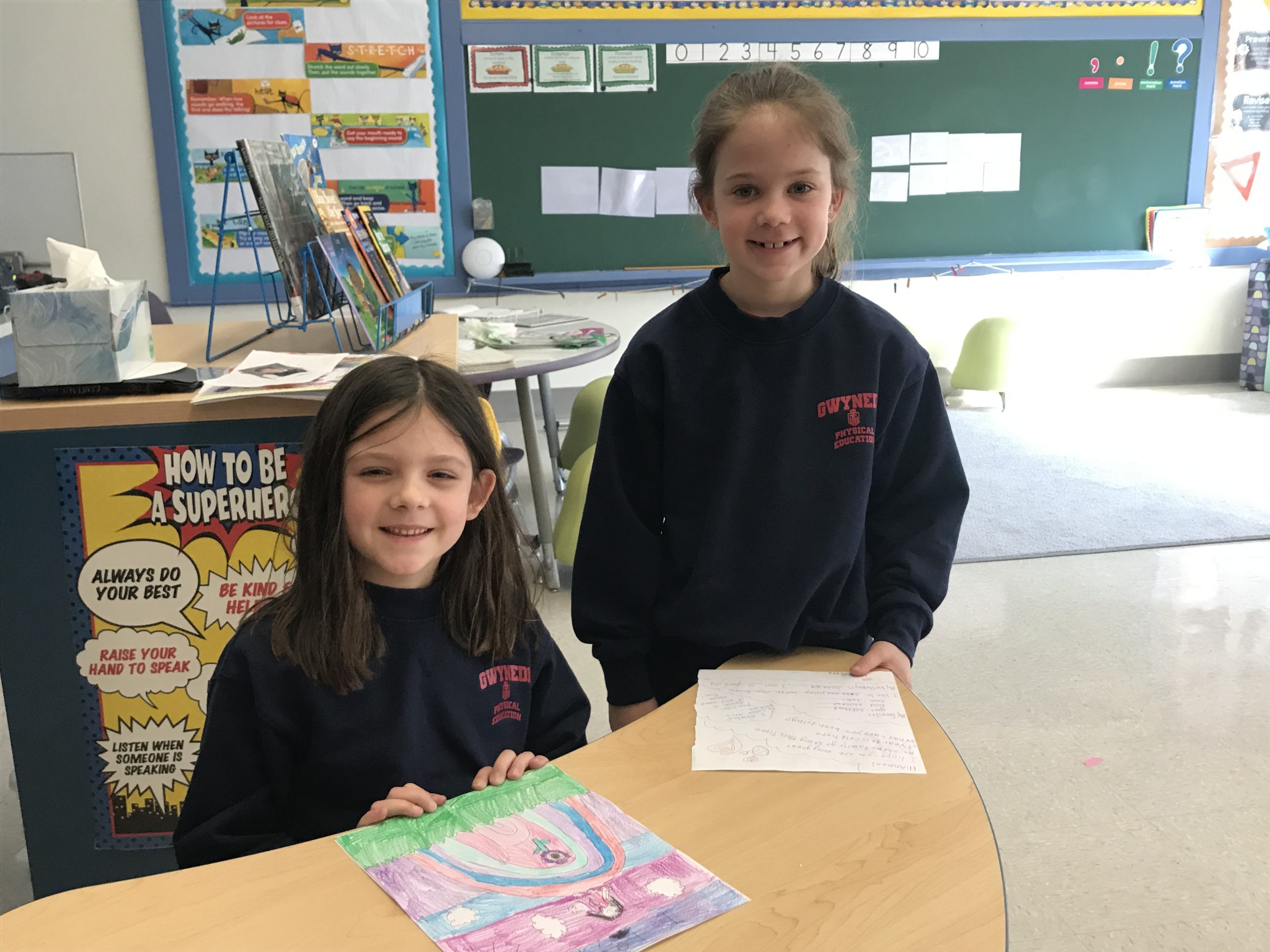 2 Gwynedd-Mercy students prepare letters to their pen pals in the Philippines.