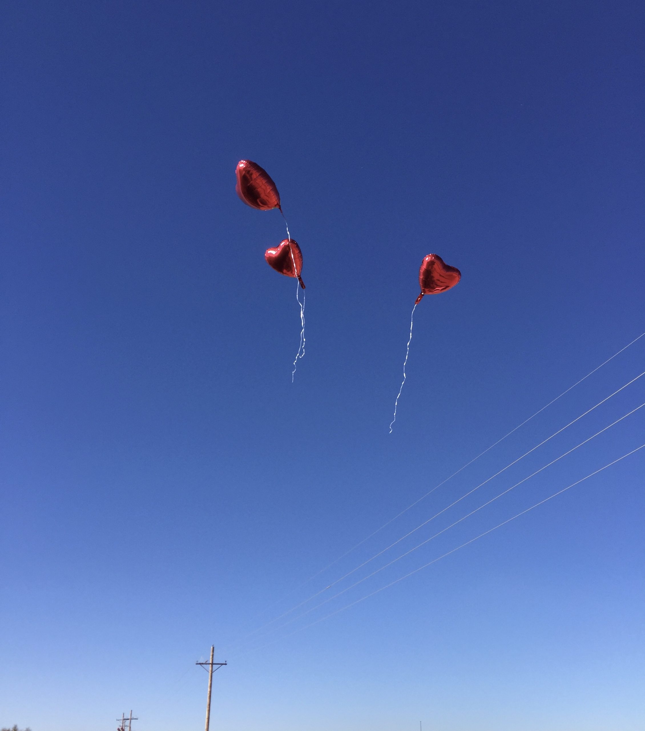 Red heart balloons released into the sky over the camp at Tornillo