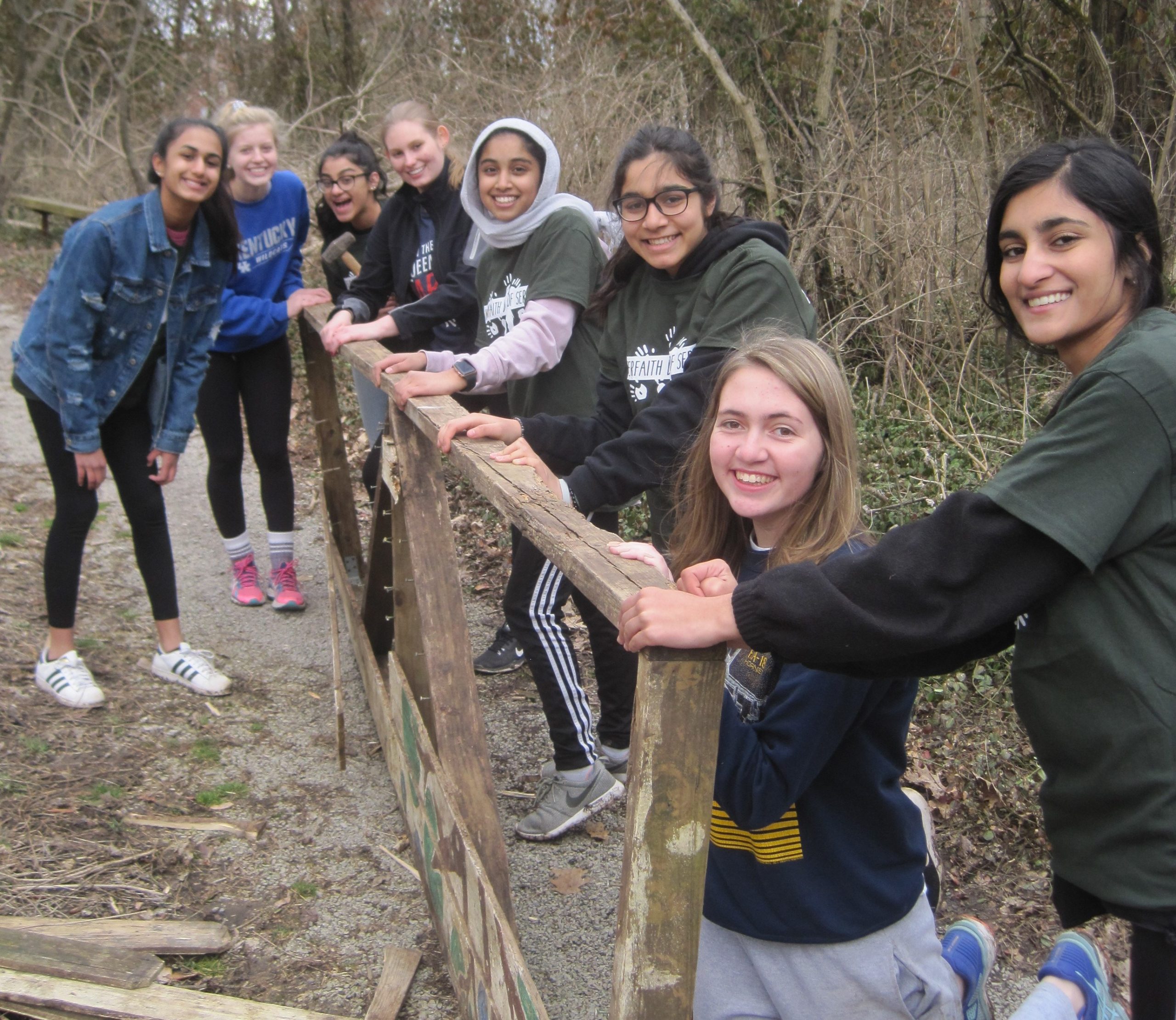 Students from the different schools stop their work improving the trails to pose for a photograph.