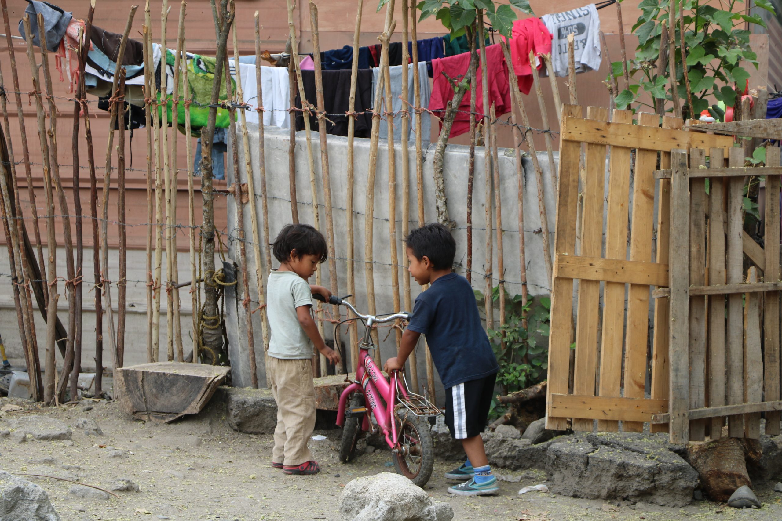 Two Honduran children play together outside of their home.