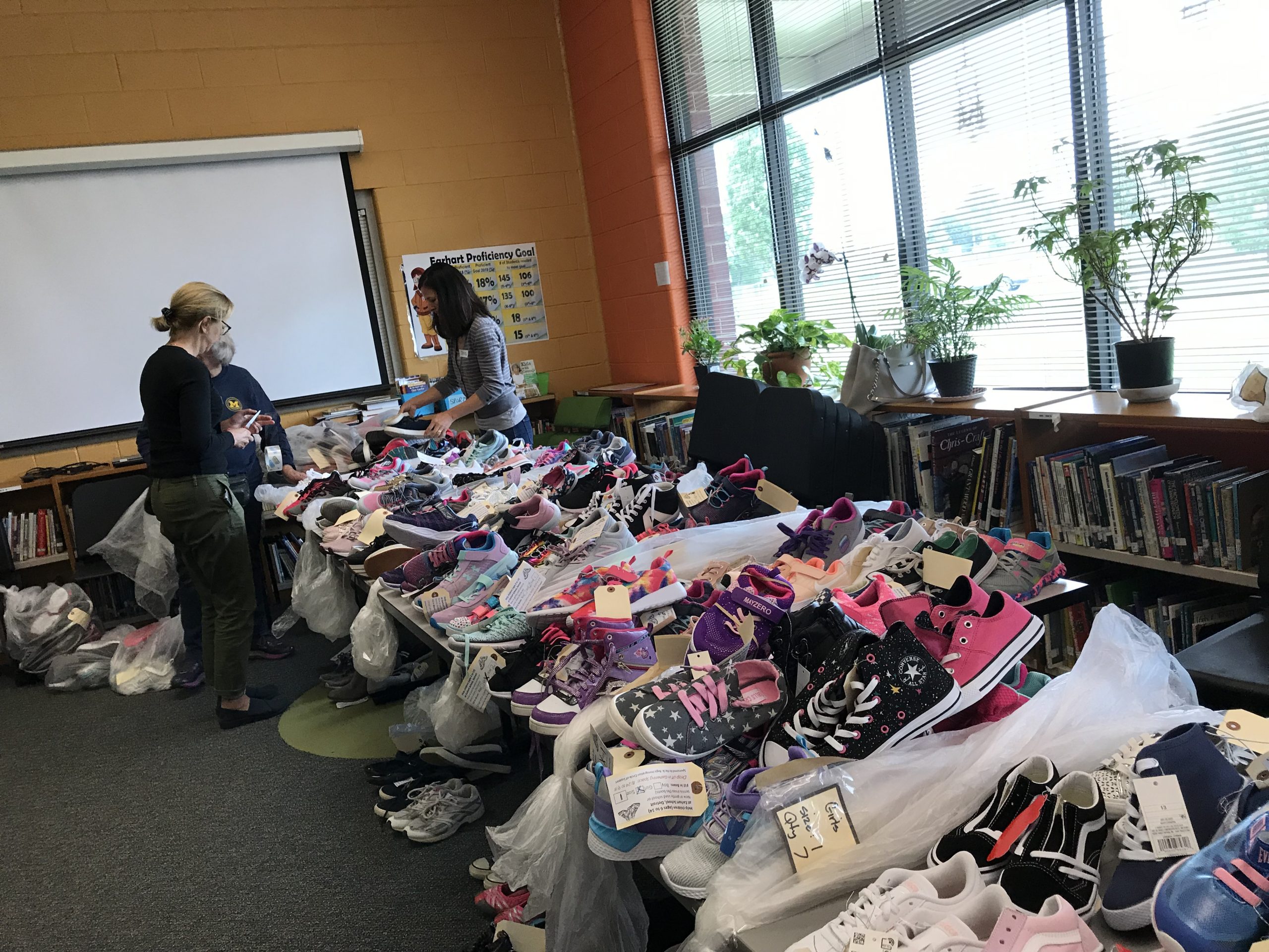 A picture of volunteers sorting through donated shoes for immigrants and children.