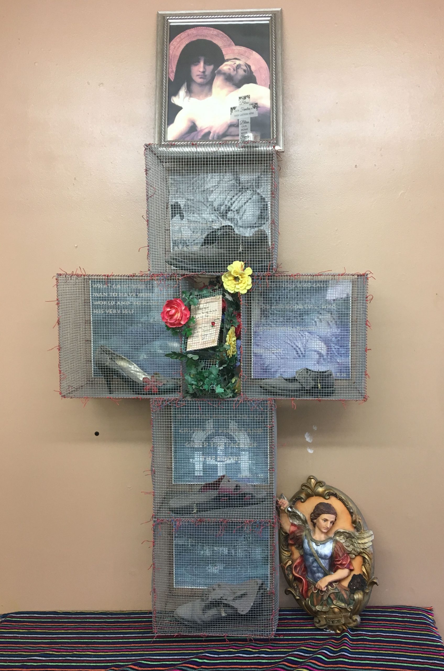 A cross on the altar at Annunciation House. Chicken wire covers shoes that were left by migrants as they crossed the border.