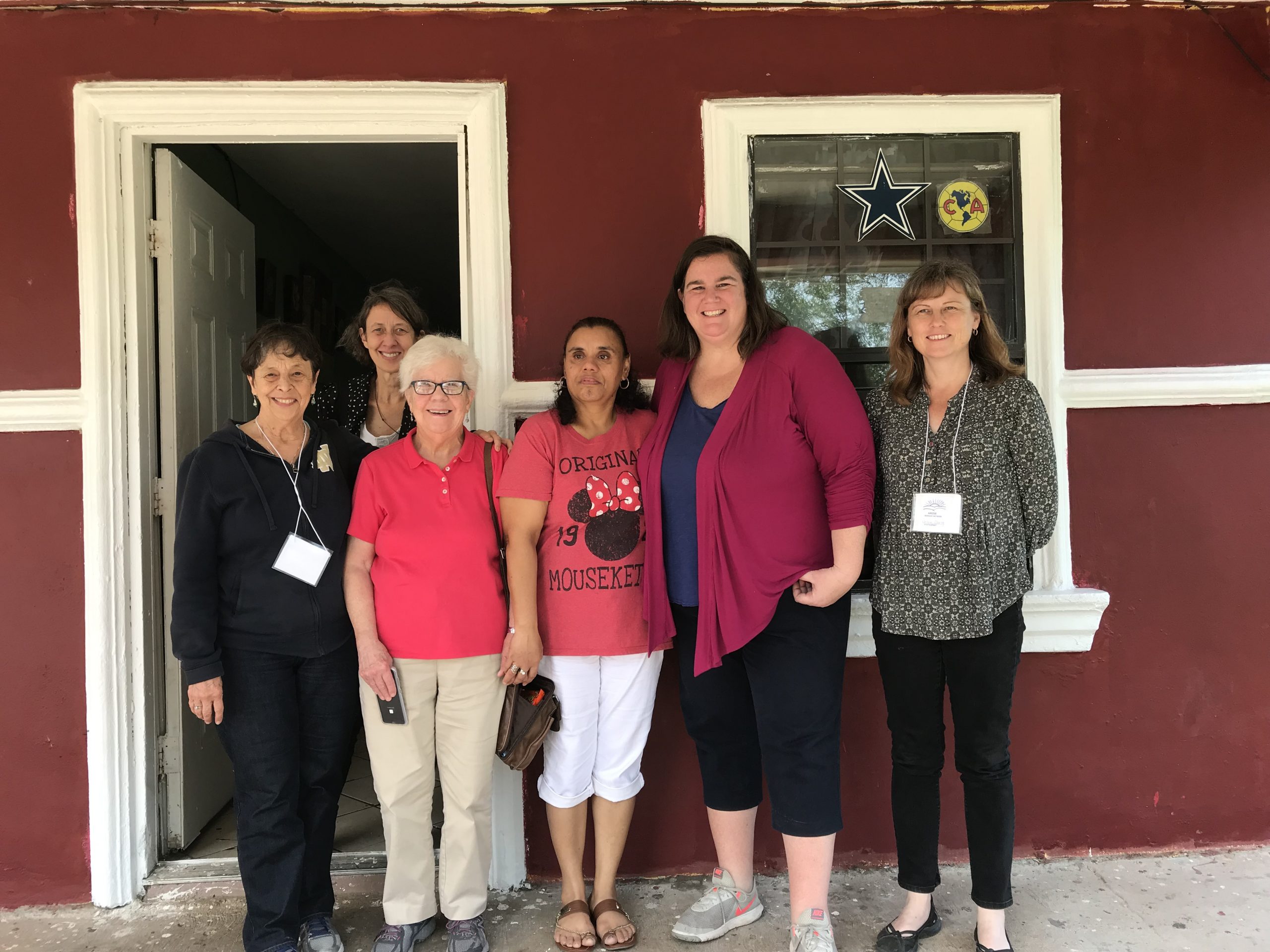 Hermana Marilyn Morgan, Jean Stokan, Hermana Joanne Whitaker, Manuela, Maggie Conley y Denise otra voluntaria, se reúnen frente a la puerta de la casa de Manuela en Alamo, Texas.
